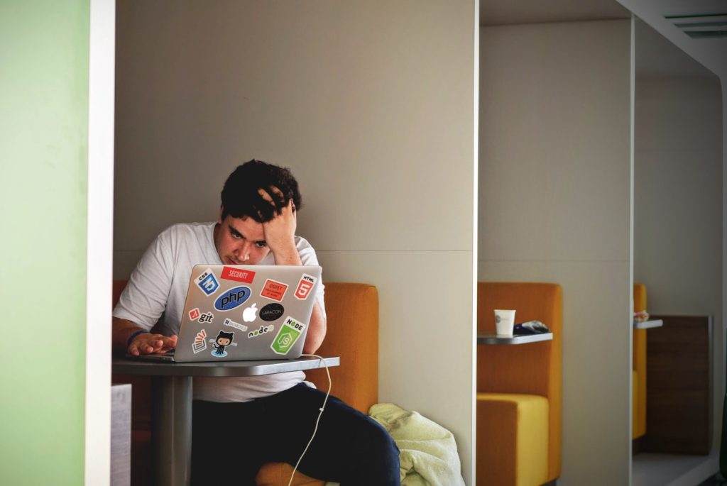 man looking frustrated using a computer in an office